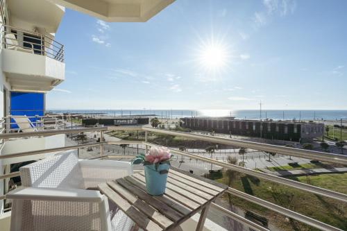 a balcony with a table and chairs and a view of the ocean at Caparica Ocean View in Costa da Caparica