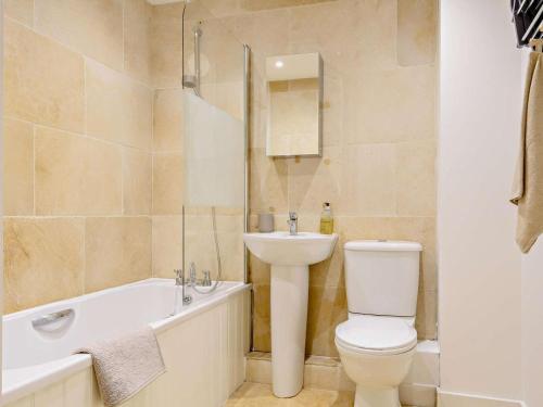 a bathroom with a toilet and a sink and a bath tub at 1 Bed in Cirencester oc-90128 in Cirencester