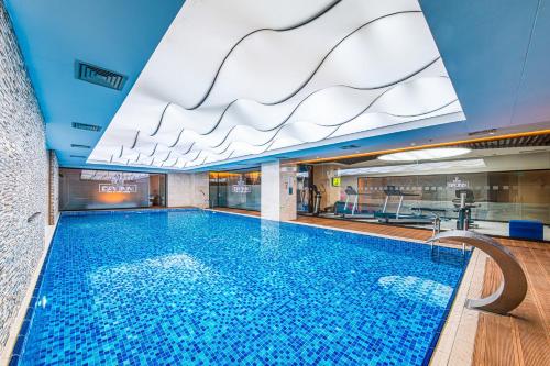 a large swimming pool in a building with a ceiling at Holiday Inn Ankara - Cukurambar by IHG in Ankara
