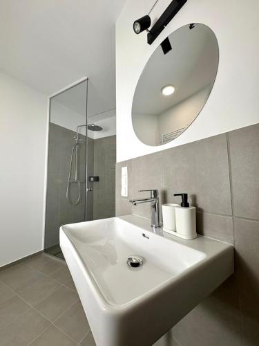 a bathroom with a white sink and a mirror at Am See 18 in Podersdorf am See