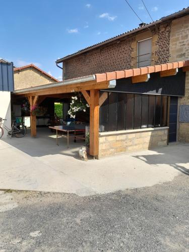 a patio with a table in front of a building at CHAMBRE PRIVÉE à LA FERME in Authe