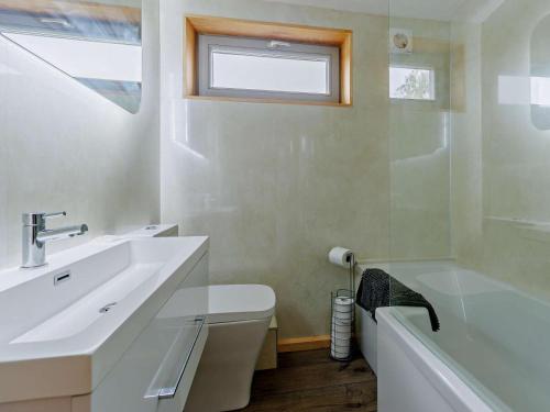 a bathroom with a sink and a toilet and a tub at 4 Bed in Shrewsbury oc-93398 in Leighton