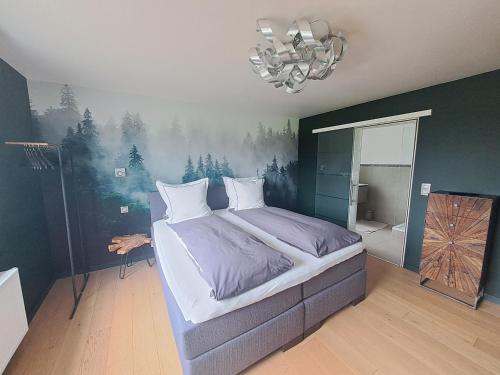 a bedroom with a bed with a painting on the wall at La Roseraie in Stavelot