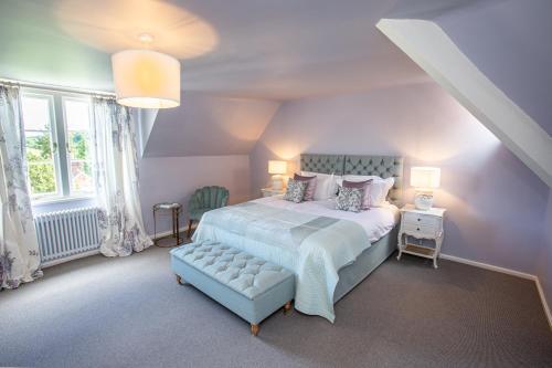 a bedroom with a large bed with a blue foot board at The Grange in Upper Arley