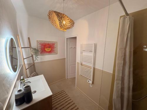 a bathroom with a sink and a mirror at Mon nid sous les toits in L'Isle-sur-la-Sorgue