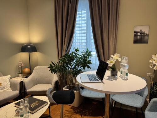 a living room with a table with a laptop on it at Residence Mutschellen in Zurich
