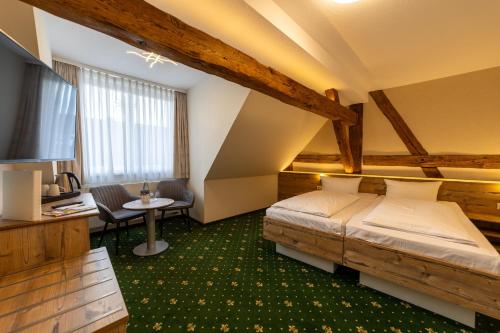 a hotel room with two beds and a desk at Hotel Zum Goldenen Löwen in Peitz