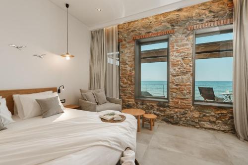 a bedroom with a large bed and a brick wall at Porto Plomari in Plomari