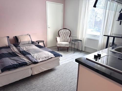 a bedroom with a bed and a chair and a sink at Cozy Studio - 7 min to Tampere Airport - Free Parking in Pirkkala