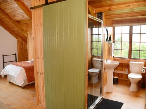 a bathroom with a green wall with a bed and a sink at Farside Macadamias in Riversdale
