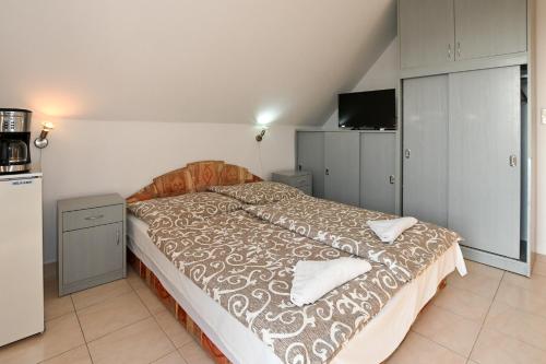 a large bed in a room with a kitchen at Klassz Apartmanház in Balatonfüred