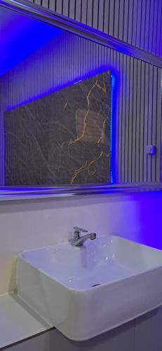 a white sink in a bathroom with a mirror at PrimeRose Residences - Near Mactan-Cebu International Airport in Lapu Lapu City