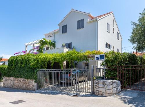 a white house with a gate in front of it at Apartment Oaza in Supetar