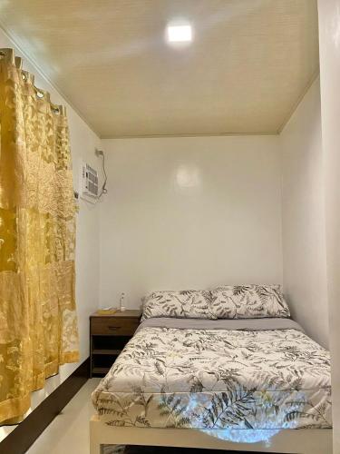 a bedroom with a bed and a yellow curtain at ErrZ Homestay in Malaybalay in Malaybalay