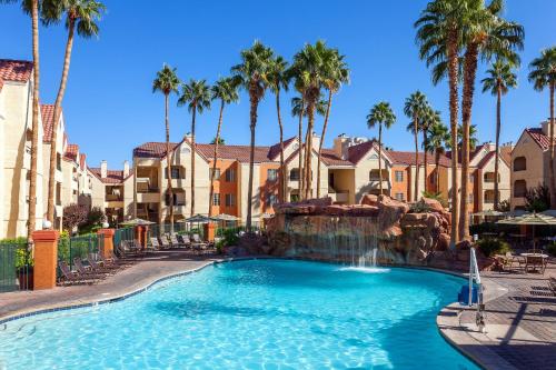 a pool at a resort with palm trees at Holiday Inn Club Vacations at Desert Club Resort in Las Vegas