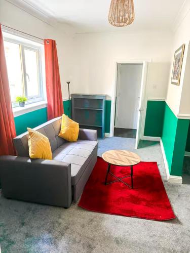 a living room with a couch and a red rug at New Hampton Units in Wolverhampton