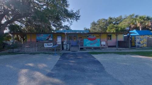 a small yellow building with a sign on it at Days Inn by Wyndham Crystal River in Crystal River