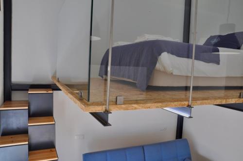 a bedroom with a bed and a glass wall at Casa de São Bento by PURUS in Coimbra