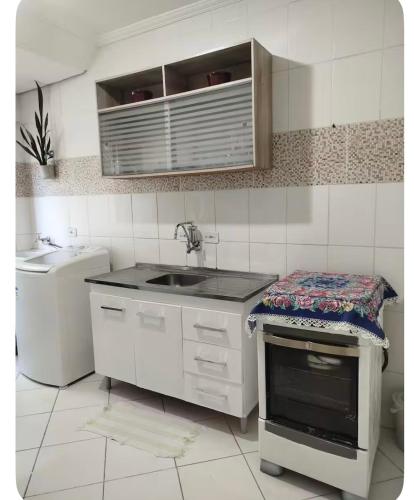 a kitchen with a sink and a counter top at Casa aconchego in São Carlos