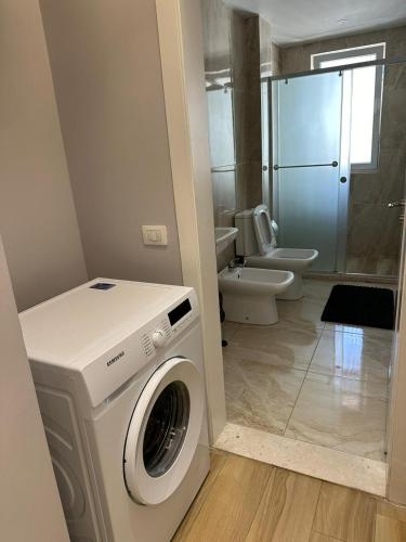 a washing machine in a bathroom with a toilet at Sevians Apartments in Golem