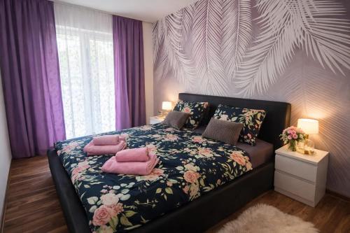 a bedroom with a bed with pink pillows on it at New Moment 2 in Žarkovo