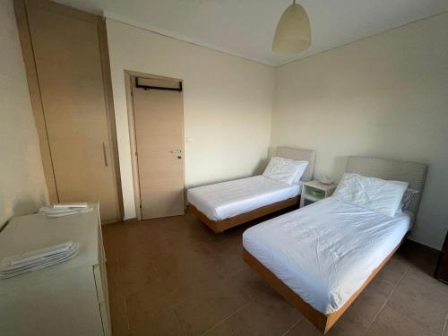 a small room with two beds and a refrigerator at Dream House in Nea Roda