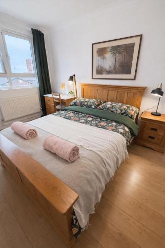 a bedroom with a large bed with two towels on it at Cosy Double Room in Shared Flat in Sutton