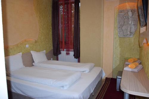 two twin beds in a room with a window at Семеен Хотел Русалка in Svishtov