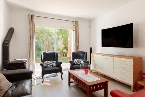 a living room with two chairs and a tv at Villa Blanca Santa Eulalia in Santa Eularia des Riu