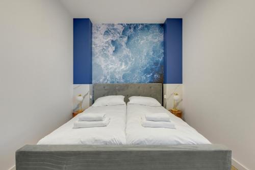 a bedroom with a bed with a painting on the wall at GRANO FLATS Sobieszewo - Villa Neptun in Sobieszewo