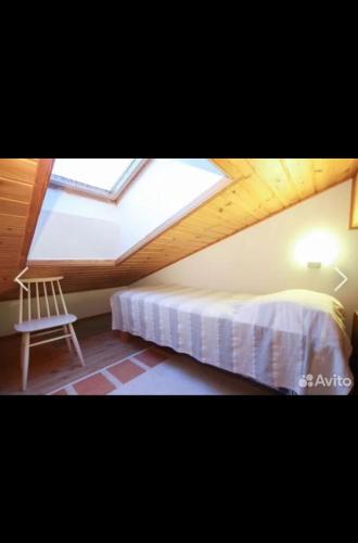 a bedroom with a bed and a skylight at Дом на берегу озера Саймаа in Ruokolahti