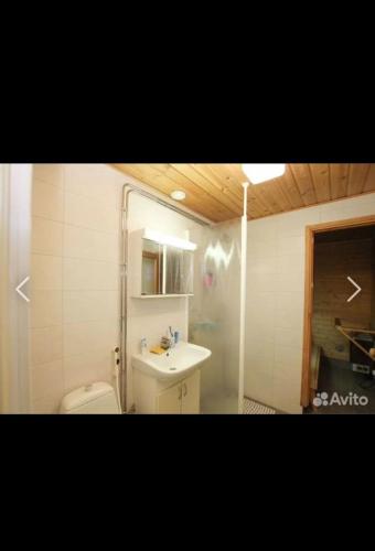 a bathroom with a white toilet and a sink at Дом на берегу озера Саймаа in Ruokolahti