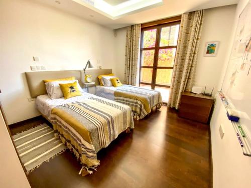 a bedroom with two beds and a window at The Amathountas Residence in Pyrgos