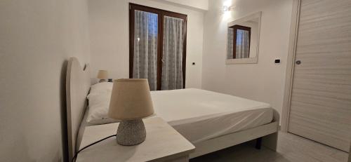 a bedroom with a bed and a table with a lamp at La Casetta Nuova struttura in Palinuro