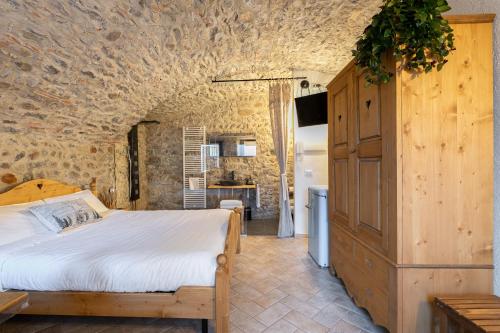 a bedroom with a bed and a stone wall at Antica corte in Zogno
