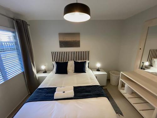 a bedroom with a large white bed with blue pillows at Central Apartment at Bismarck5 in Swakopmund