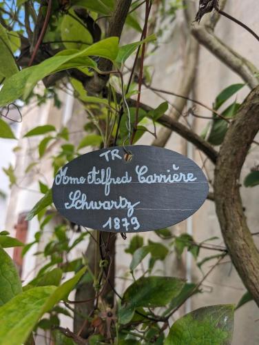 a sign hanging from a tree with writing on it at La rose d'Alfred in Chédigny
