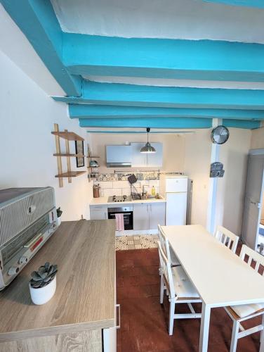 a kitchen with a table and a white table and chairs at La rose d'Alfred in Chédigny