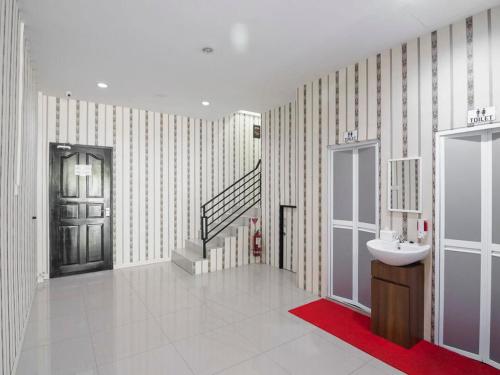 a bathroom with a sink and a stairwell with a sink at RedDoorz @ Baloi Batam in Batam Center