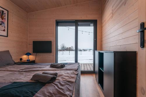 a room with two beds and a television in a room at Derylovka - domki, jacuzzi, sauna in Zamość