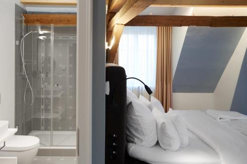 a bedroom with a bed and a bathroom with a shower at GUT LEBEN am Morstein in Westhofen