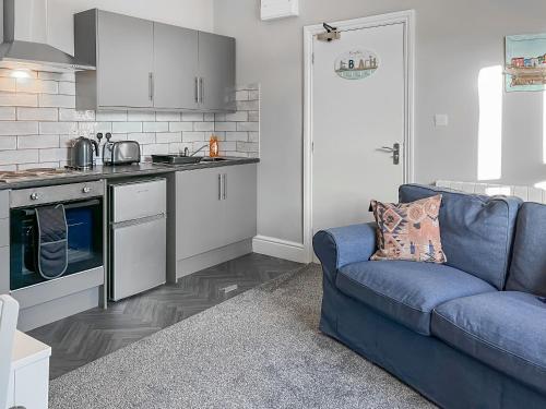 a living room with a blue couch in a kitchen at Rose - Uk49363 in Bridlington