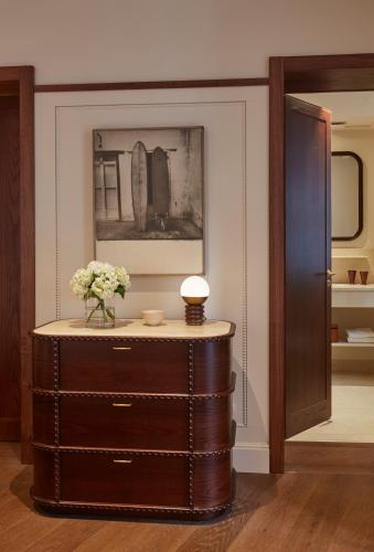 a dresser with a vase of flowers on top of it at Hotel de Silhouette in Biarritz