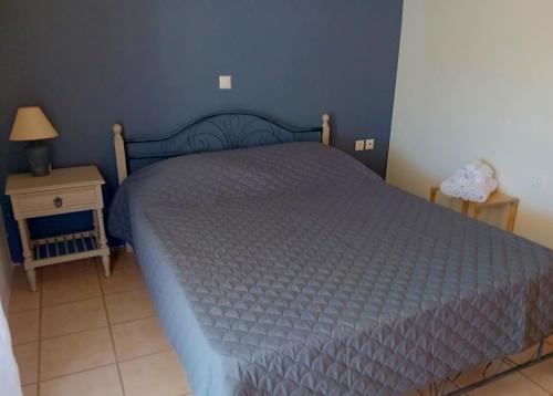 a bedroom with a bed and a table with a lamp at Στης Χαράς in Porto Heli