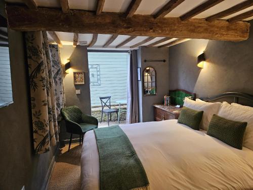 a bedroom with a bed and a table and chairs at Cotswold Cottage Guest House in Stow on the Wold