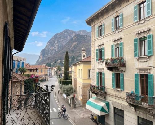a person riding a bike down a street next to buildings at Menaggio Lake Como Elegance in Menaggio