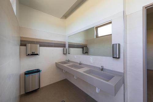 a bathroom with two sinks and a mirror at Sonnenkap Camping in Prenzlau
