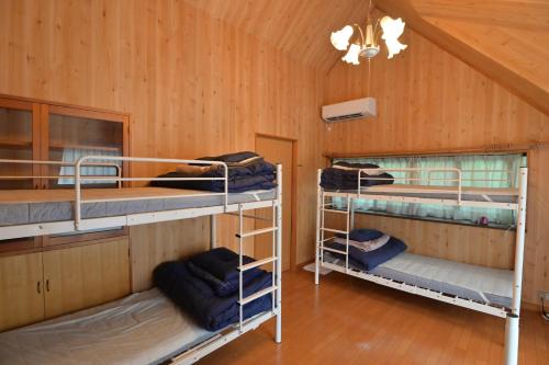 two bunk beds in a room with wooden walls at ve-nasu本館 in Nasu