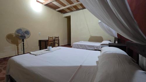 two beds in a room with a fan and a room with two beds at Centro Ecoturistico Ya´ajche in Lacanjá