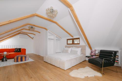 a bedroom with a bed and a couch and a chair at The Loft in Sovata